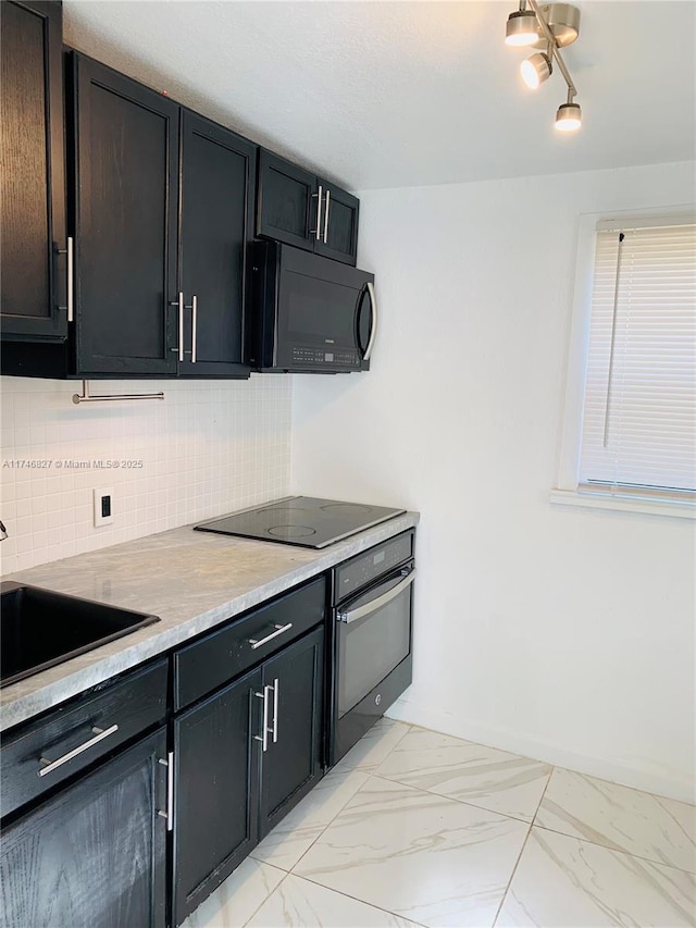 kitchen with decorative backsplash, sink, light stone counters, and black appliances