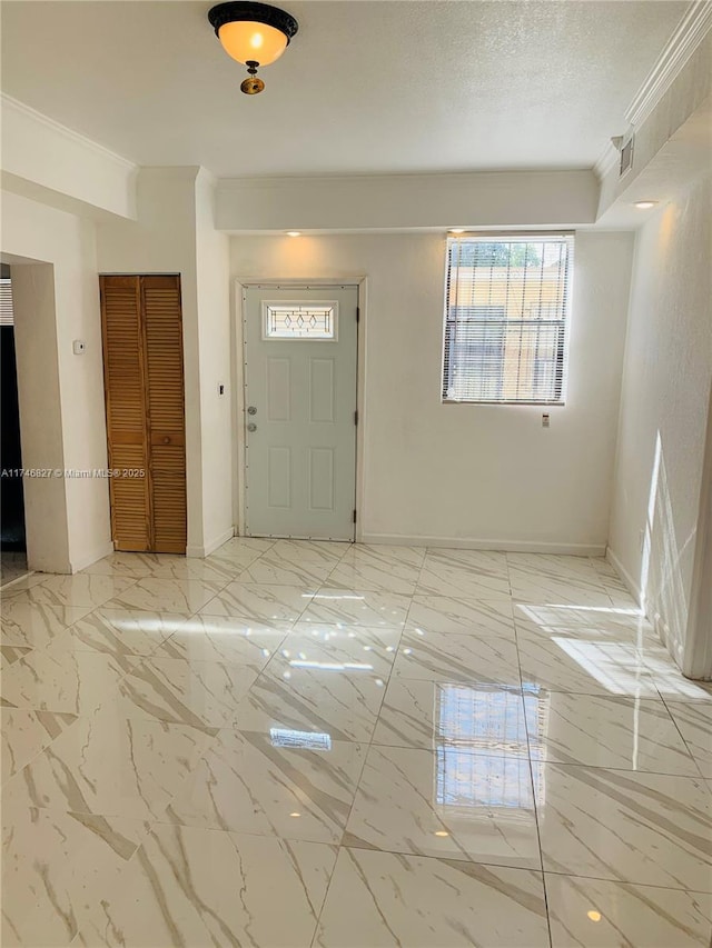 entryway with crown molding and a textured ceiling