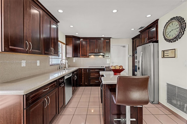 kitchen with light tile patterned floors, visible vents, stainless steel appliances, under cabinet range hood, and a sink