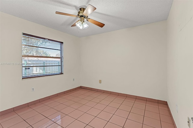 spare room featuring light tile patterned flooring, ceiling fan, and a textured ceiling