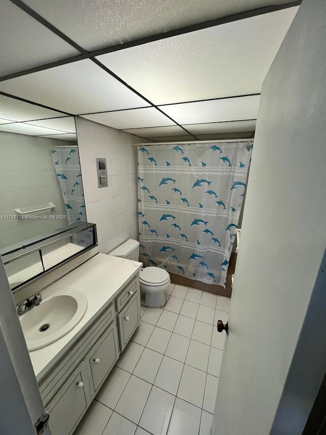 bathroom featuring curtained shower, tile patterned flooring, vanity, and toilet