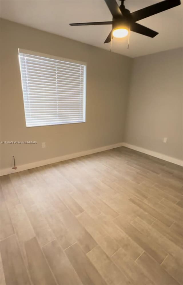 unfurnished room featuring ceiling fan and light hardwood / wood-style flooring