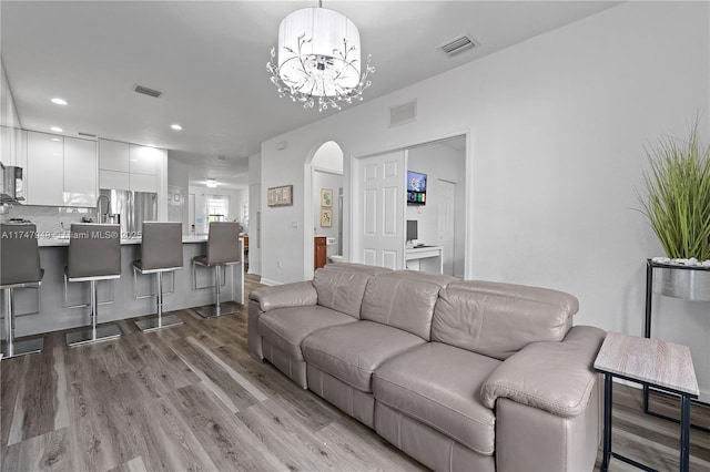 living room featuring a notable chandelier and light hardwood / wood-style flooring