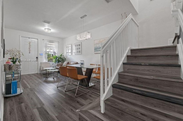 dining room featuring a textured ceiling and dark hardwood / wood-style flooring