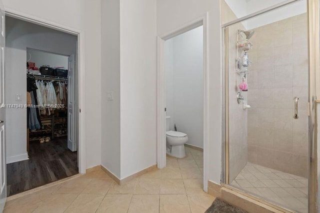 bathroom with tile patterned floors, toilet, and walk in shower
