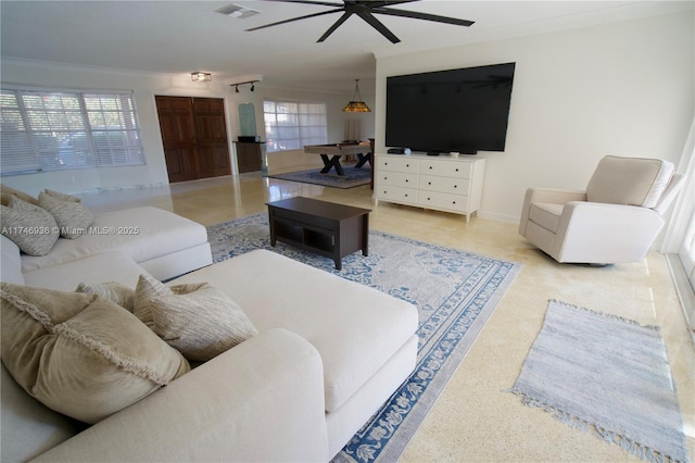 living area with a ceiling fan, visible vents, crown molding, and baseboards