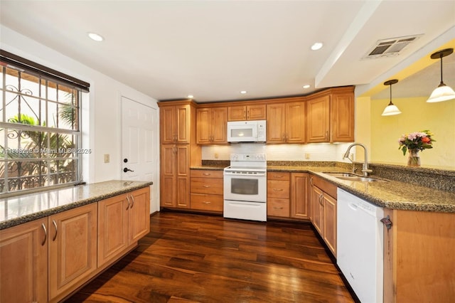 kitchen featuring white appliances, dark wood-type flooring, pendant lighting, sink, and dark stone countertops