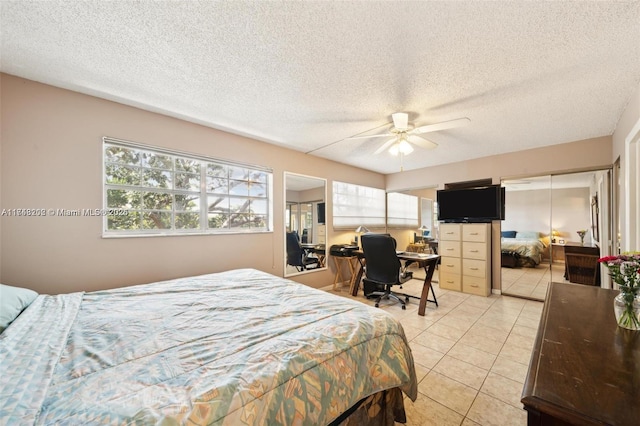 tiled bedroom featuring ceiling fan and a textured ceiling