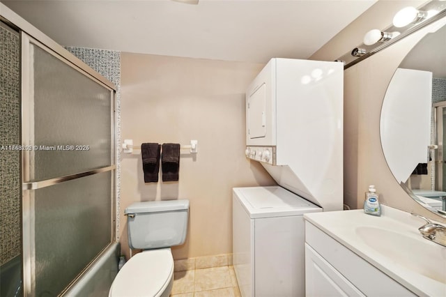 full bathroom with toilet, tile patterned floors, stacked washing maching and dryer, enclosed tub / shower combo, and vanity