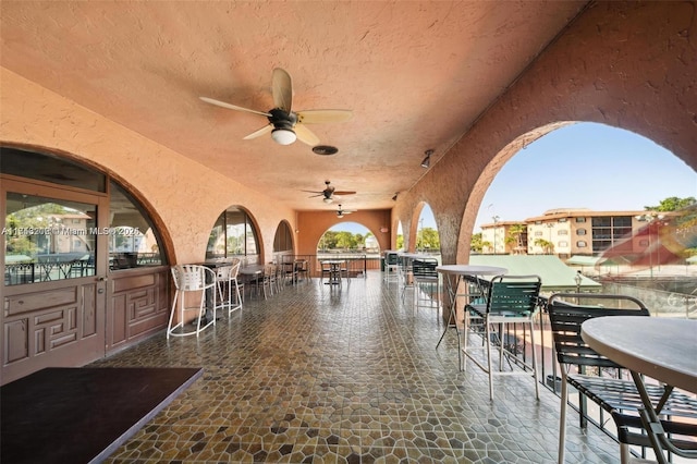 view of patio with a water view and a bar