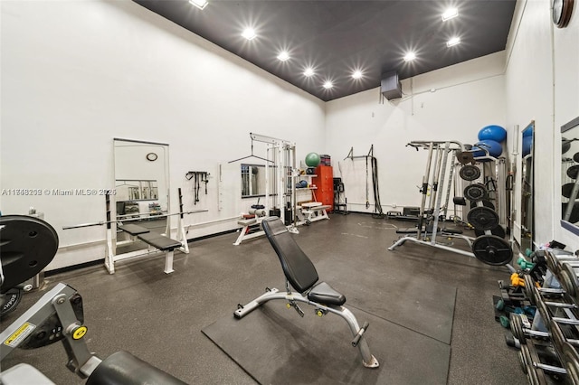 workout area featuring a towering ceiling