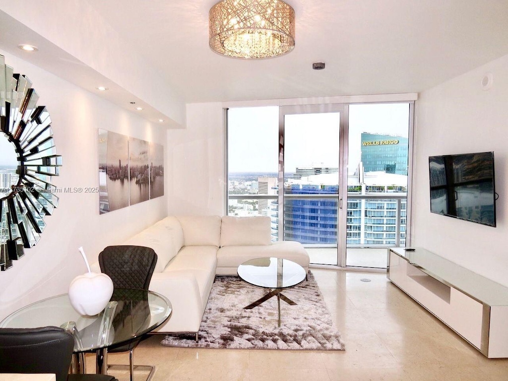 living room with an inviting chandelier, expansive windows, and recessed lighting