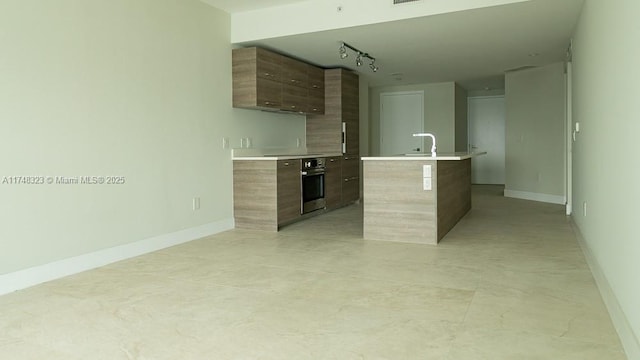 650 NE 32nd St Unit 2105, Miami, FL 33137 - kitchen with modern cabinets, oven, light countertops, a center island with sink, and track lighting