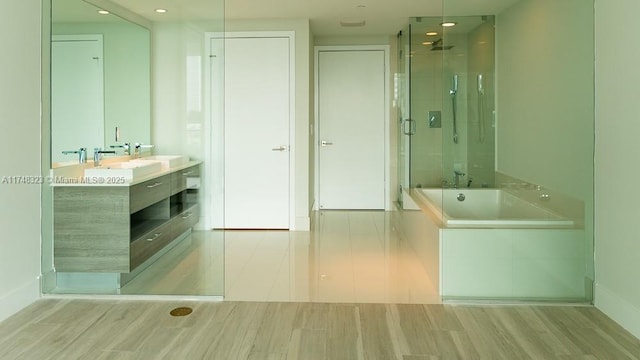 650 NE 32nd St Unit 2105, Miami, FL 33137 - bathroom with a shower stall, a bath, double vanity, wood finished floors, and recessed lighting