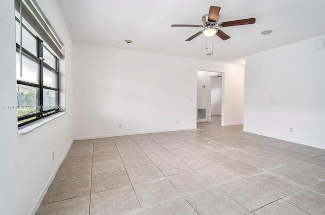 unfurnished room with a ceiling fan, visible vents, baseboards, and light tile patterned floors