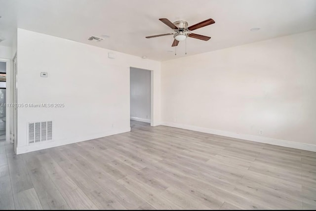 unfurnished room with light wood finished floors, baseboards, and visible vents