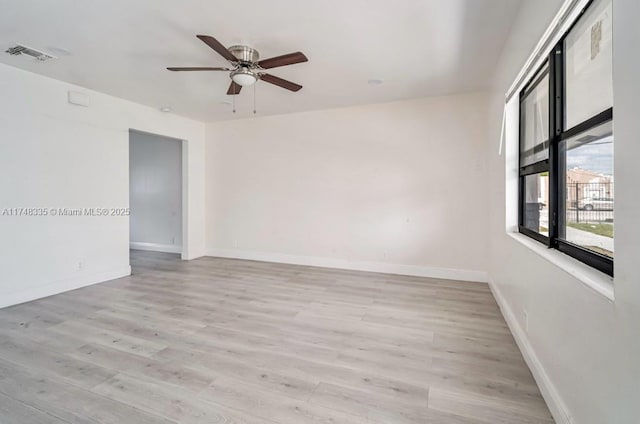 unfurnished room featuring baseboards, ceiling fan, visible vents, and light wood-style floors