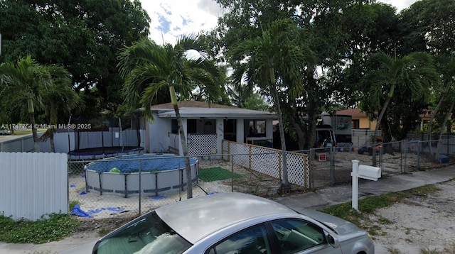 view of front of house featuring fence and a fenced in pool