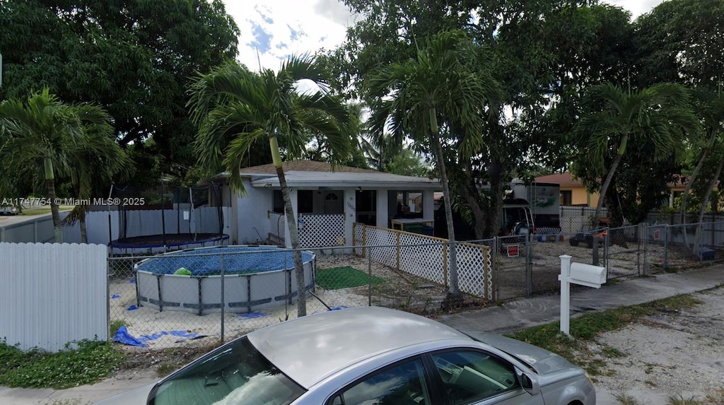 view of front of house with a fenced in pool and fence