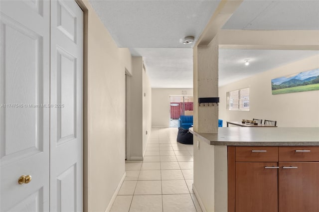 hallway with light tile patterned floors and a textured ceiling