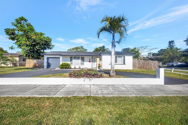 ranch-style home featuring a front lawn and a garage