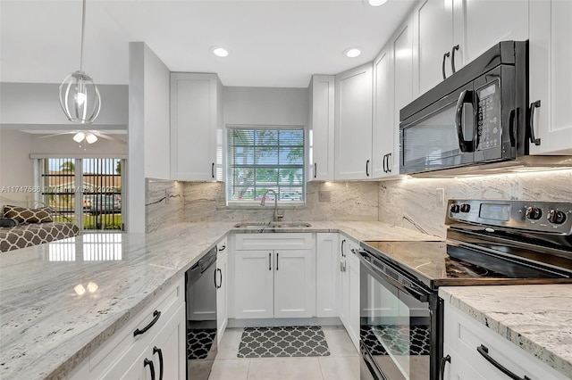 kitchen with white cabinetry, hanging light fixtures, black appliances, light stone countertops, and sink