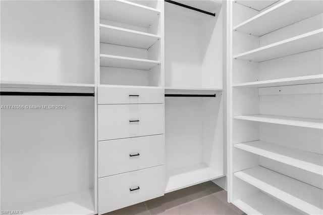 spacious closet with dark tile patterned floors