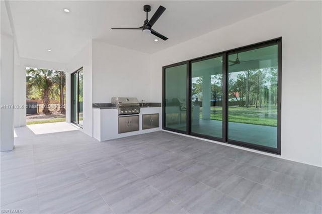 view of patio / terrace featuring ceiling fan, a grill, and exterior kitchen