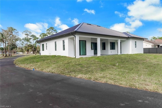 rear view of house featuring a lawn