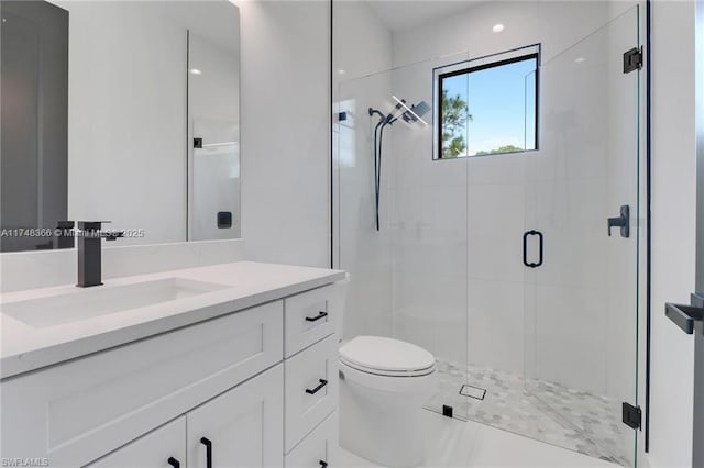 bathroom featuring toilet, a shower with shower door, and vanity