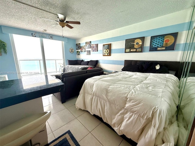 tiled bedroom featuring ceiling fan and a textured ceiling