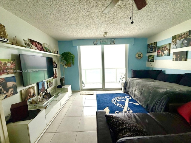 living room with light tile patterned floors, ceiling fan, and a textured ceiling