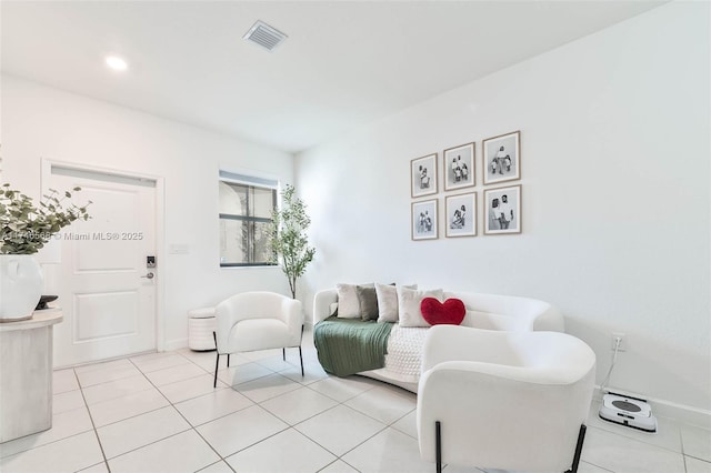 living room featuring light tile patterned floors, baseboards, and visible vents