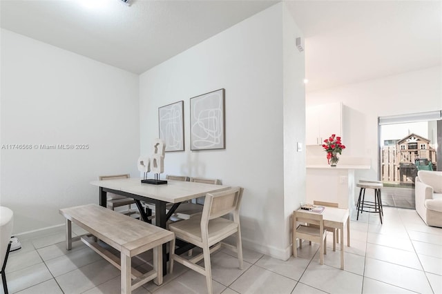 dining space with light tile patterned floors and baseboards