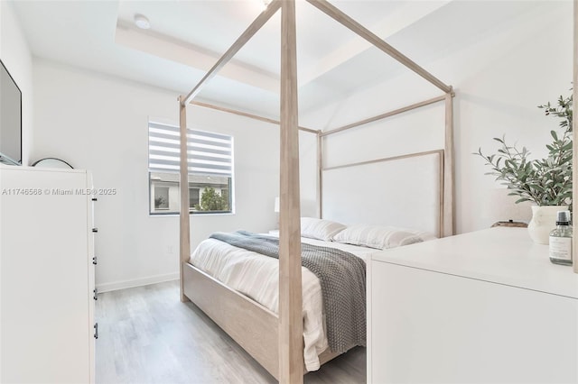 bedroom with light wood-style flooring and baseboards