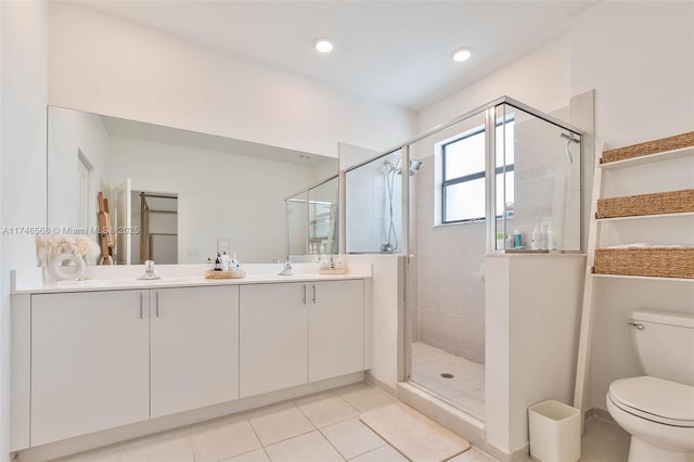 bathroom featuring double vanity, toilet, a sink, a shower stall, and tile patterned floors