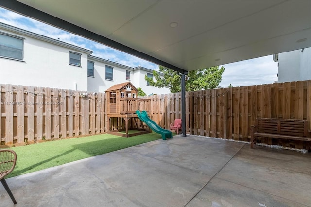 view of patio / terrace featuring a playground and fence