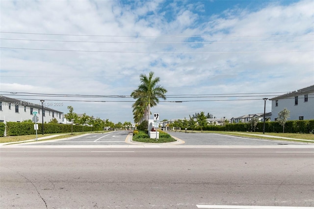 view of street featuring sidewalks, traffic signs, a residential view, and curbs