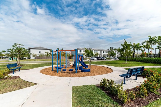 communal playground featuring a residential view and a yard