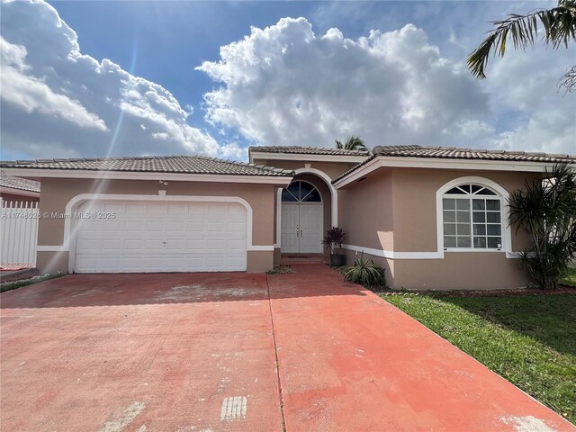 mediterranean / spanish-style home with driveway, an attached garage, and stucco siding