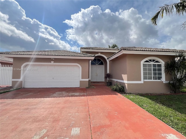 mediterranean / spanish home with a garage, driveway, and stucco siding