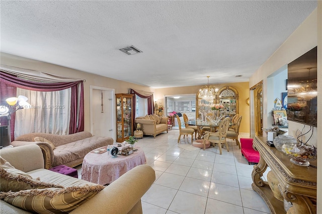 living area with light tile patterned floors, visible vents, a textured ceiling, and an inviting chandelier