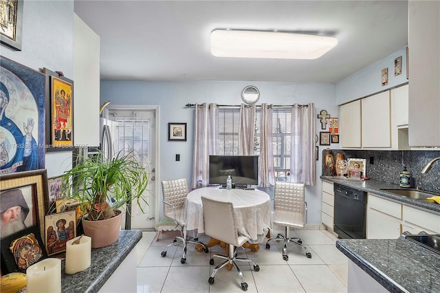 kitchen featuring decorative backsplash, dishwasher, white cabinetry, a sink, and light tile patterned flooring