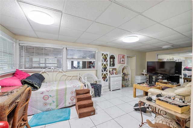 living room with light tile patterned floors and a paneled ceiling