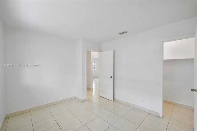 spare room with visible vents, baseboards, and light tile patterned floors
