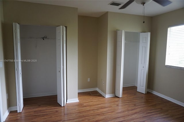 unfurnished bedroom with multiple windows, a closet, hardwood / wood-style flooring, and ceiling fan
