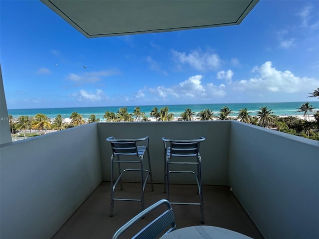 balcony with a water view and a beach view