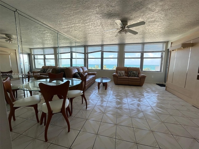 living room with ceiling fan and a textured ceiling