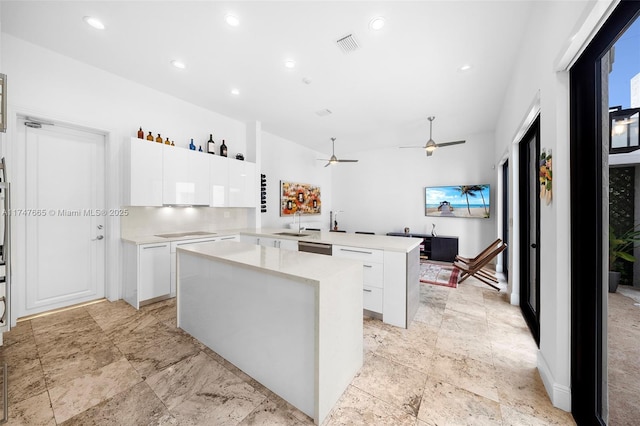 kitchen featuring dishwasher, white cabinets, a center island, sink, and kitchen peninsula
