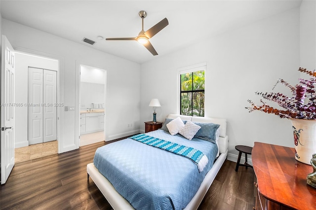 bedroom with ceiling fan, connected bathroom, and dark hardwood / wood-style flooring